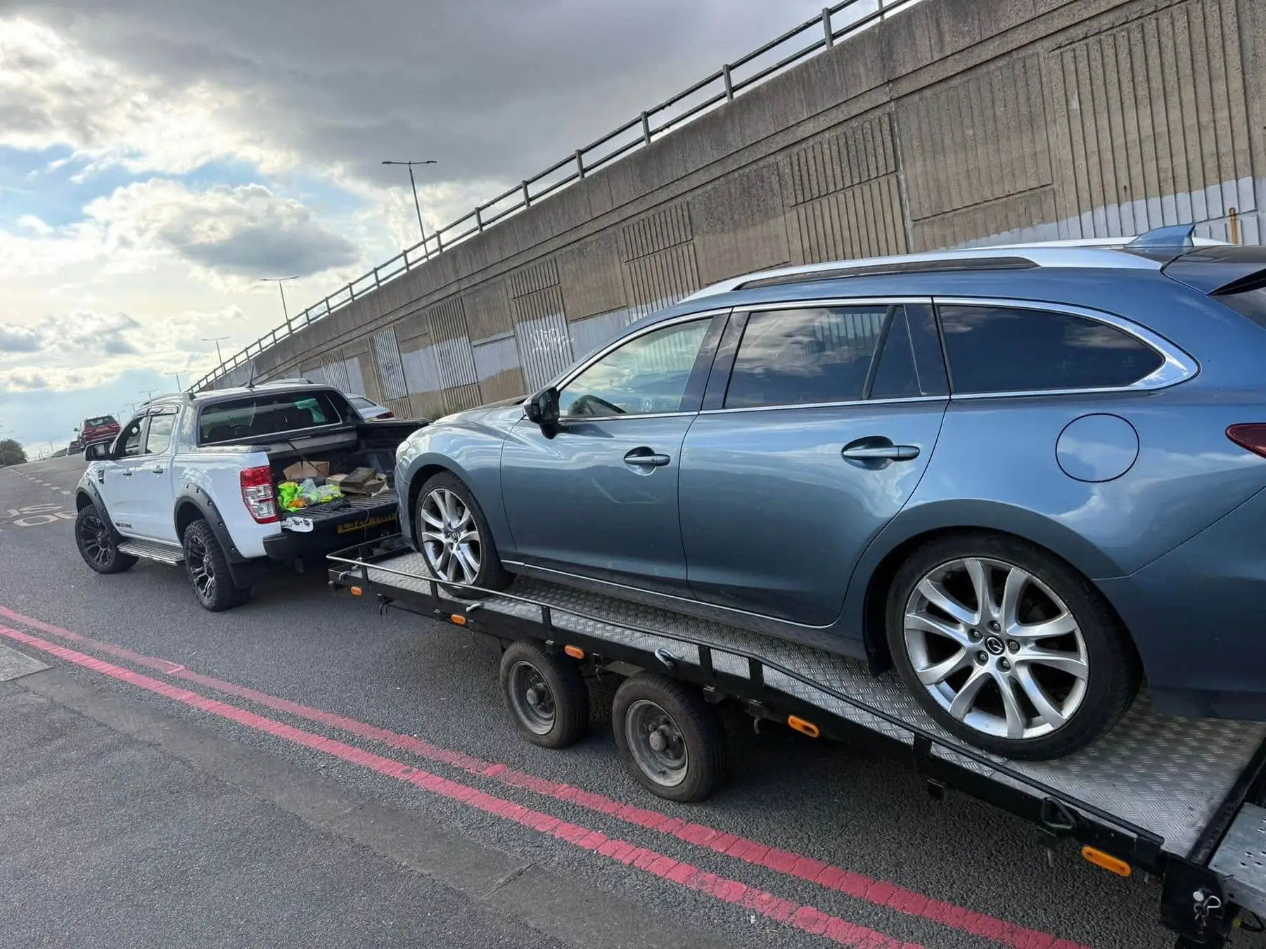 Rear view of a recovered estate car on the trailer behind the LTR Ford Ranger